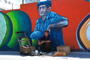 Cuba Santiago de Cuba 'a street seller before wall painting'